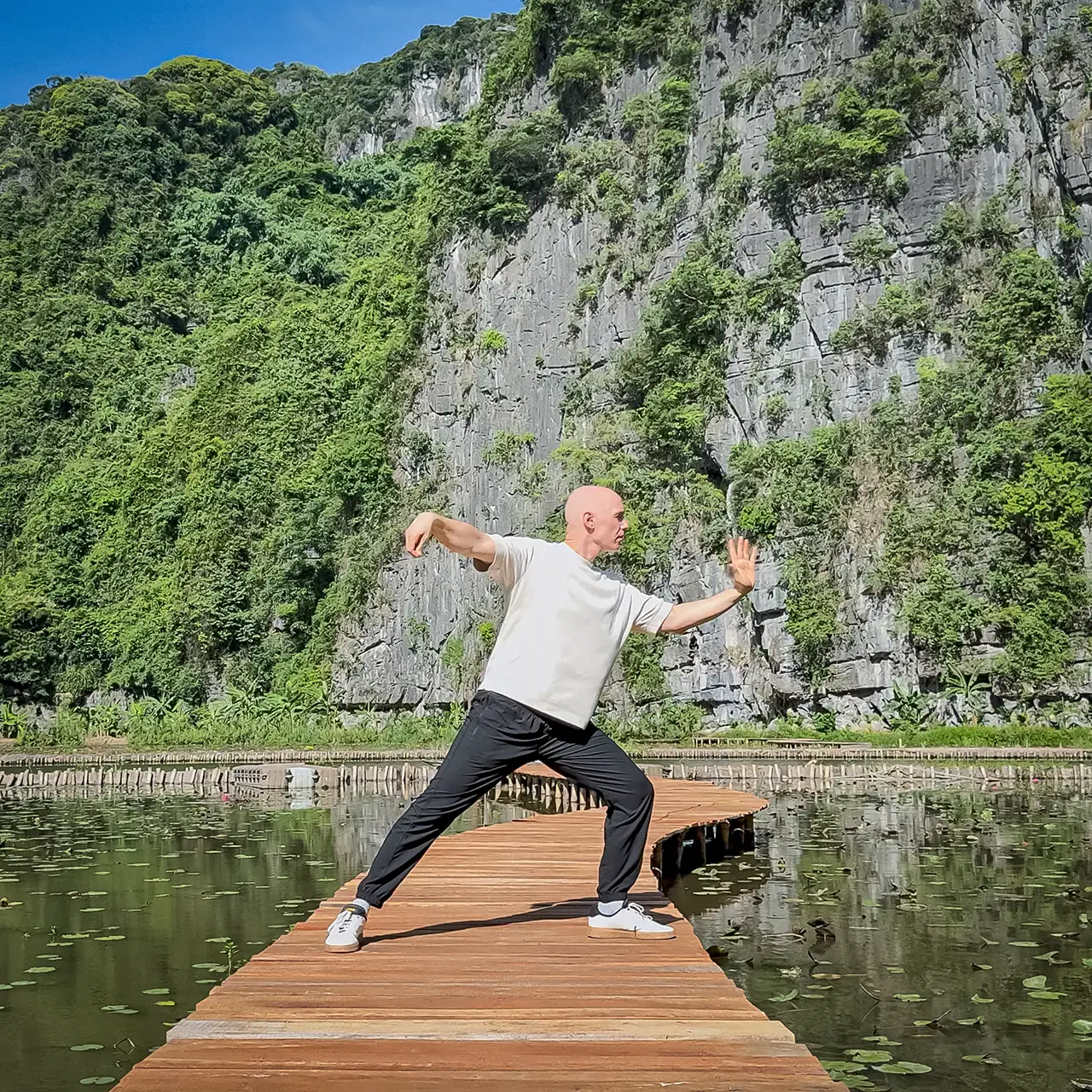 Valerio Bellone practicing Tai Chi Chuan on a wooden walkway
